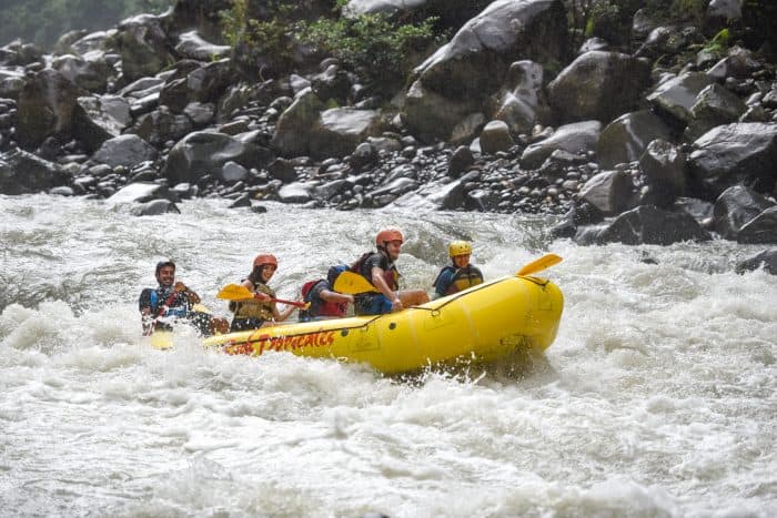 Rafters new to the Pacuare River enjoy the ride — but notice how hard the man in back is working.