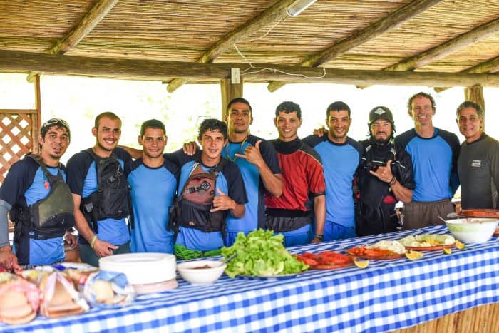 Guides, kayakers and friends: Lunch is served. Daniel Bustos Araya, making the hand sign at center, leads rafting, canopy and canyoning tours and does mixed martial arts in his spare time.