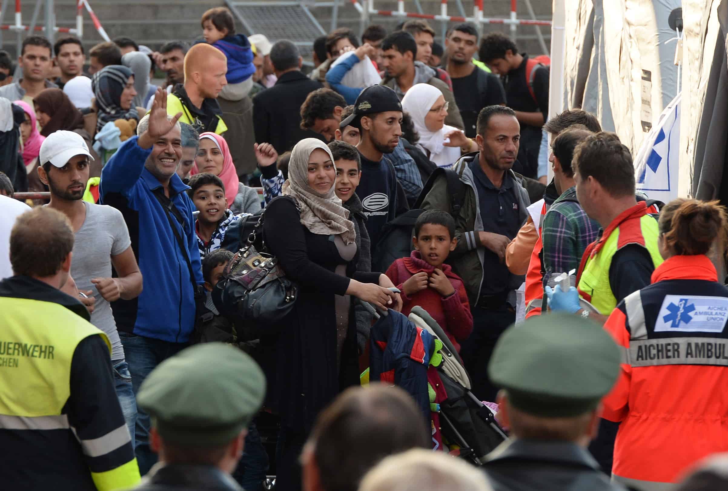Incoming refugees wait for a short first medical check after their arrival in front of the main train station in Munich, southern Germany, Sept. 5, 2015.