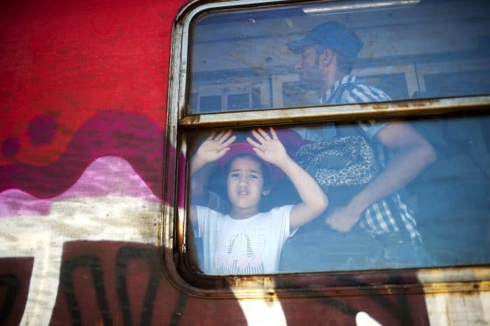 A boy looks through the window of a train.