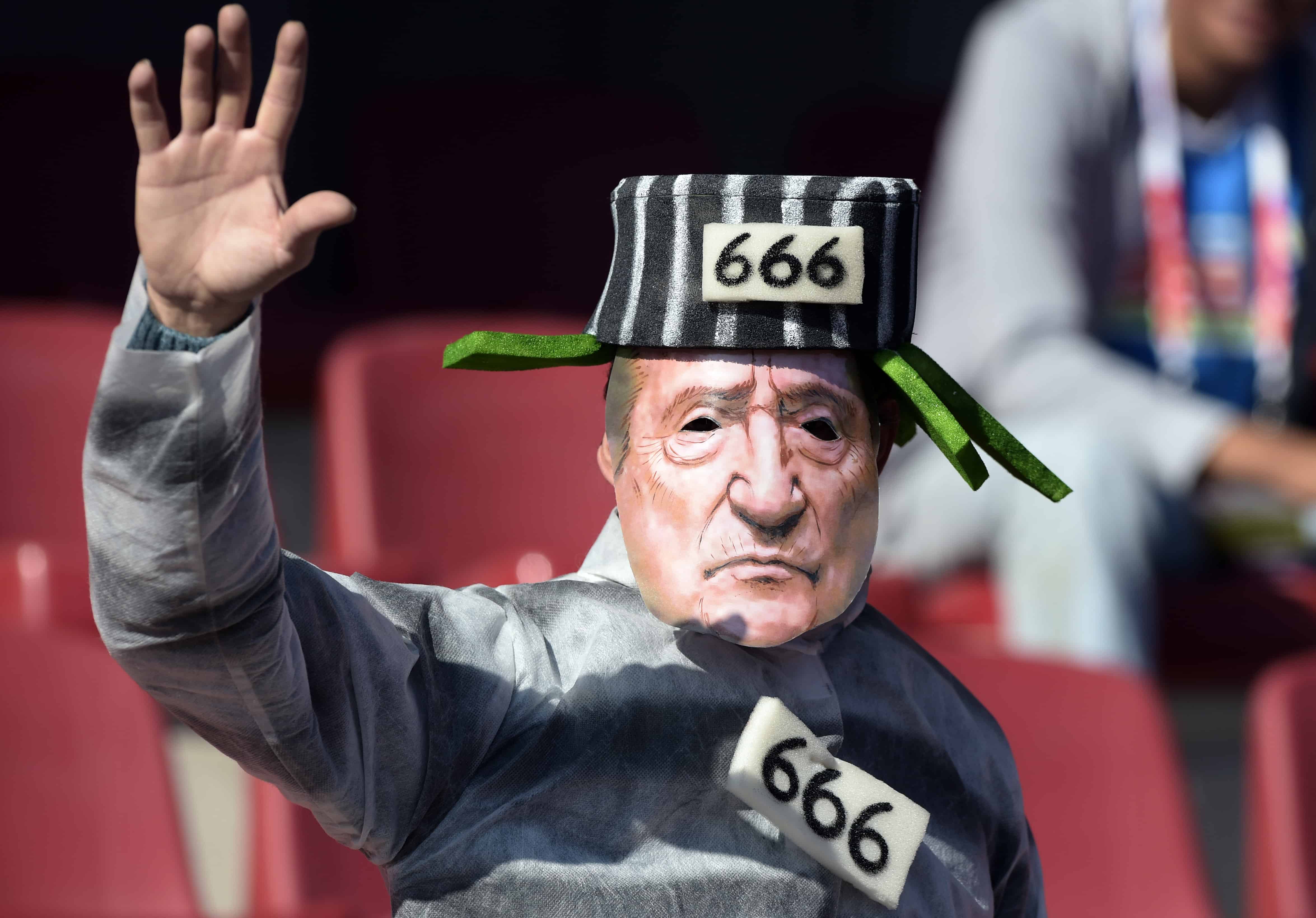 Following FIFA corruption probe, a fan sports a Eugenio Figueredo mask.