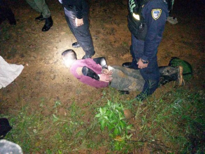A suspected poacher handcuffed on the ground