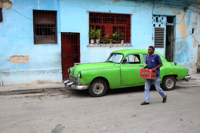 A man carries a case of beer through the streets of Havana.