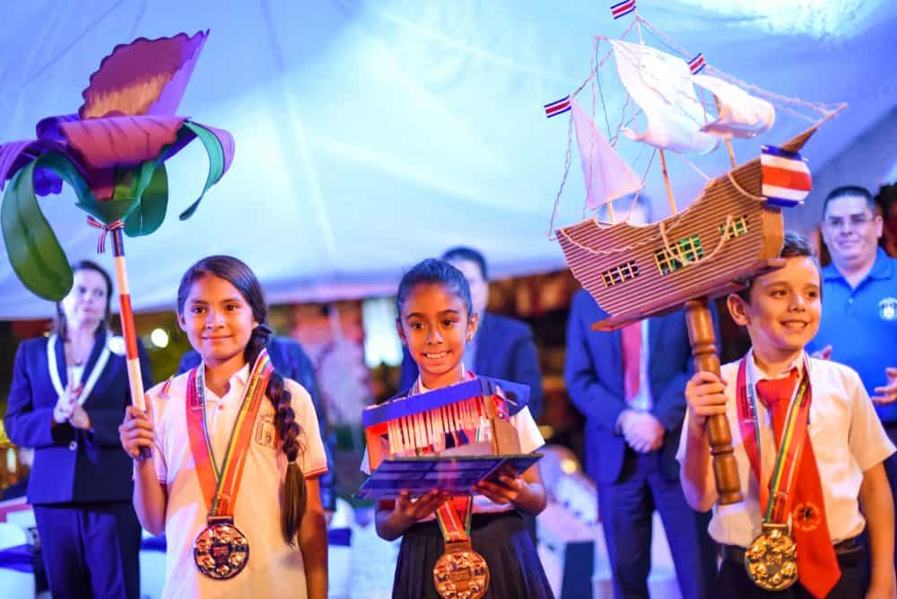 Children proudly displaying their hand-made lanterns in vibrant colors during the desfile de faroles, representing Costa Rica’s independence and enlightenment.