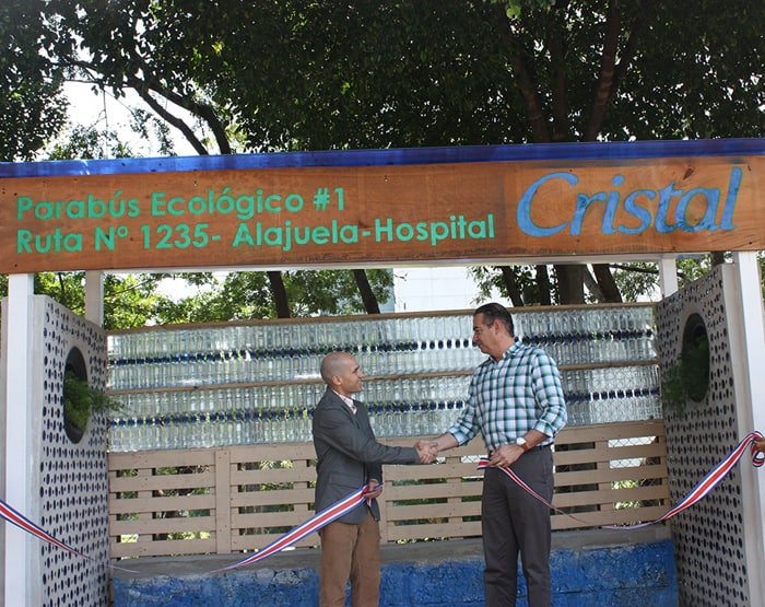 Felipe Guardia of Cristal Water, left, shakes hands with Alajuela Mayor Roberto Thompson on Thursday at the ribbon-cutting for a bus stop made of recycled water bottles.