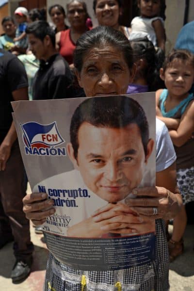 woman with poster of Jimmy Morales