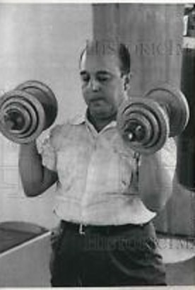 Venezuelan President Marcos Pérez Jiménez pumping iron.