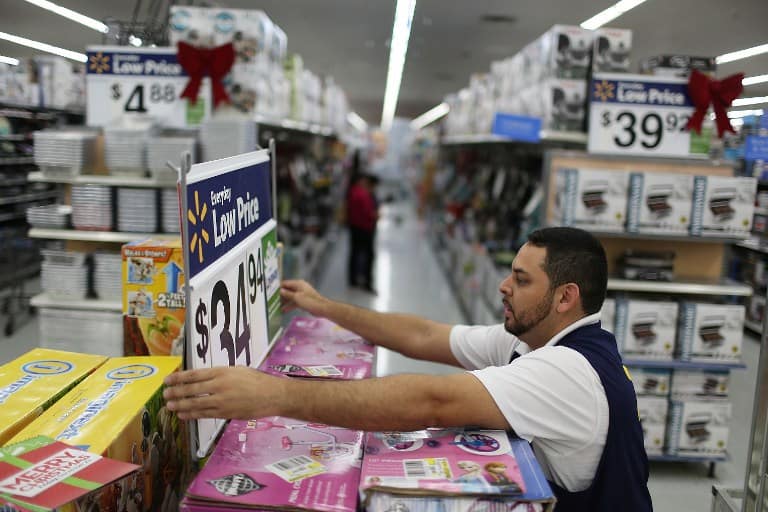 MIAMI, FL - NOVEMBER 24: Jaime Vado fixes a display in the isle at a Walmart store as they prepare for Black Friday shoppers on November 24, 2015 in Miami, Florida. Black Friday, which is the day after Thanksgiving, is known as the first day of the Christmas shopping season and most retailers offer special deals on the day.