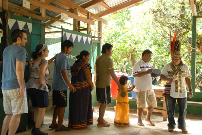 Tourists participate in a ceremonial dance with members of the indigenous Ngäbe tribe.