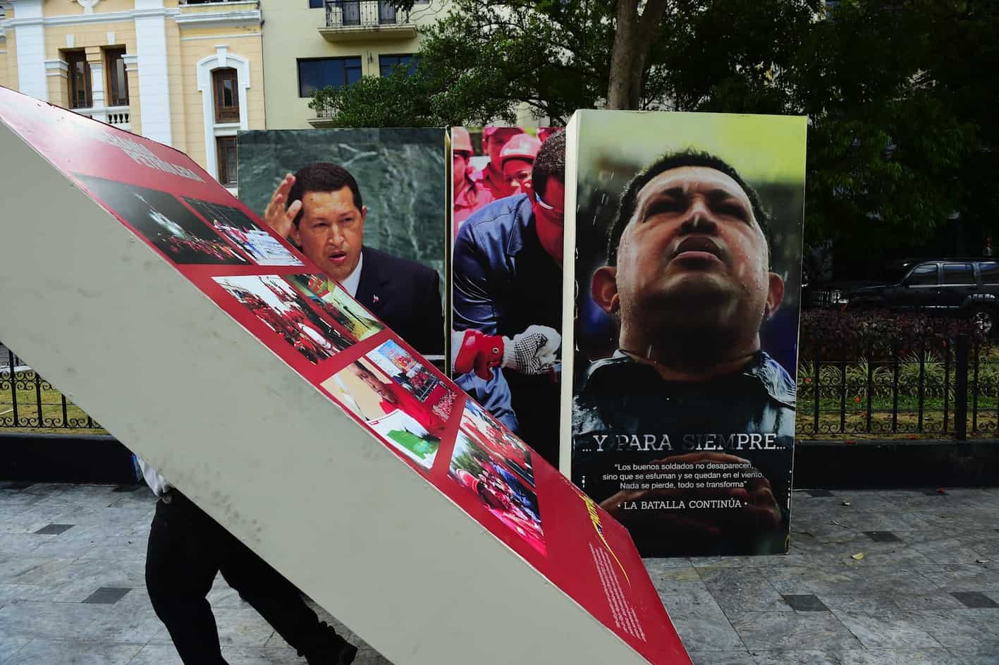 Venezuela National Assembly employees carrying images of Hugo Chávez