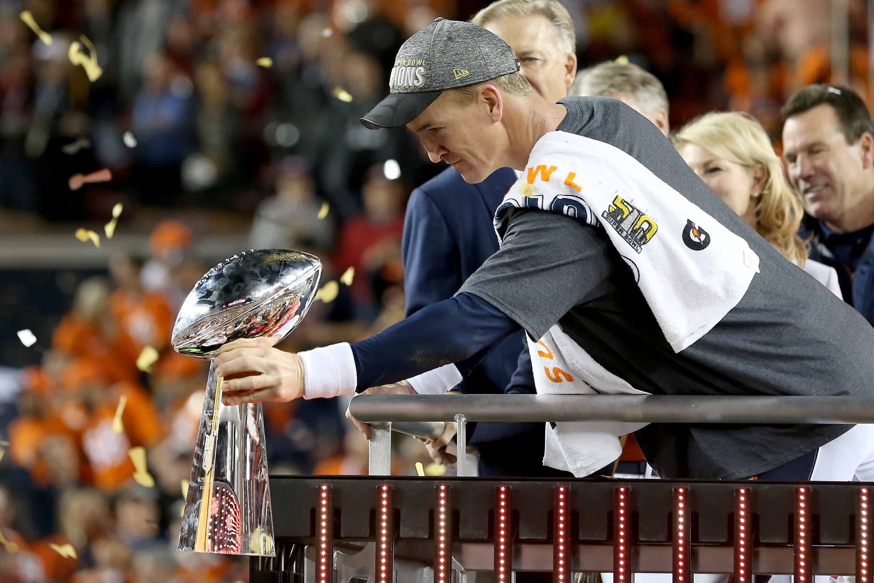 Peyton Manning of the Denver Broncos hands the Vince Lombardi Trophy to teammates in Super Bowl 50.