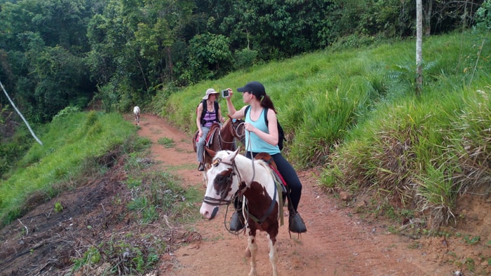 Mia takes a picture of the scenery near Dos Brazos while her mom, Cindy, and a riderless pony bring up the rear.