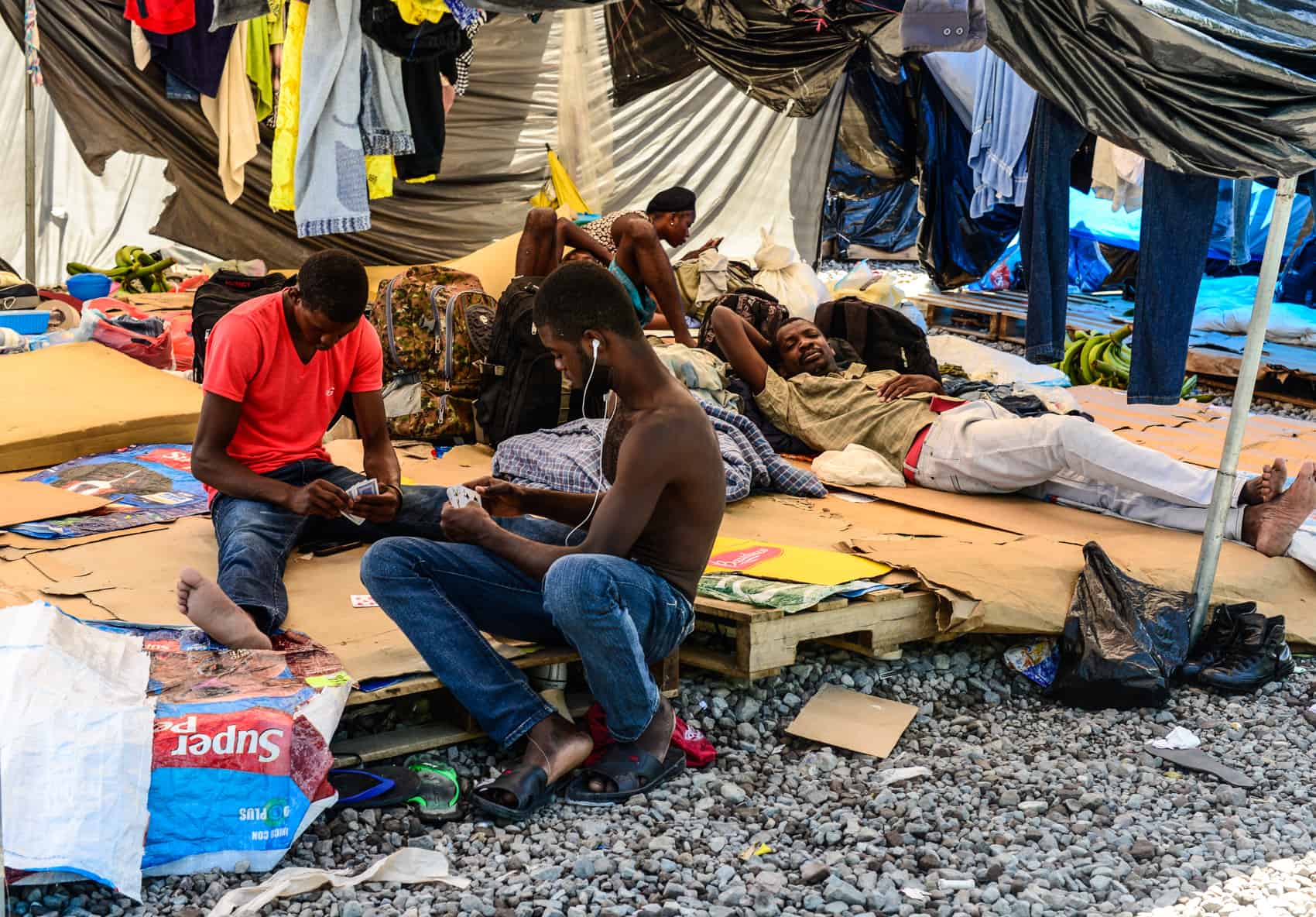 African migrants play cards in a Red Cross tent.
