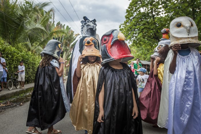 Children dress up as birds in costumes designed by naturalist artist Luis Entique to highlight their importance to this coast.