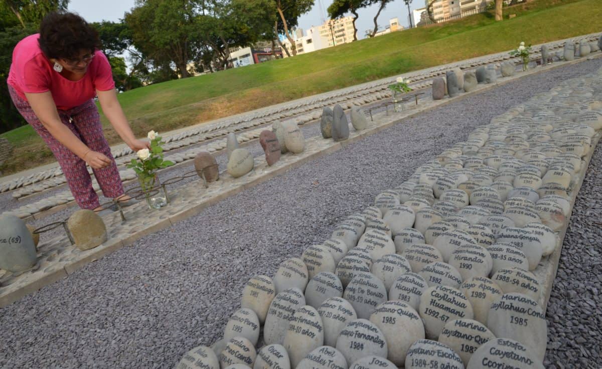 A relative of a victim of the regime of former Peruvian President (1990-2000) Alberto Fujimori places flowers at the Eye That Cries Monument in Lima on February 2, 2018, to demand the annulment of a humanitarian pardon granted to him by Peruvian President Pedro Pablo Kuczynski. A hearing was held at the Inter-American Court on Human Rights in San Jose, Costa Rica Friday to rule against a pardon for Fijimori, who was serving a 25-year sentence.