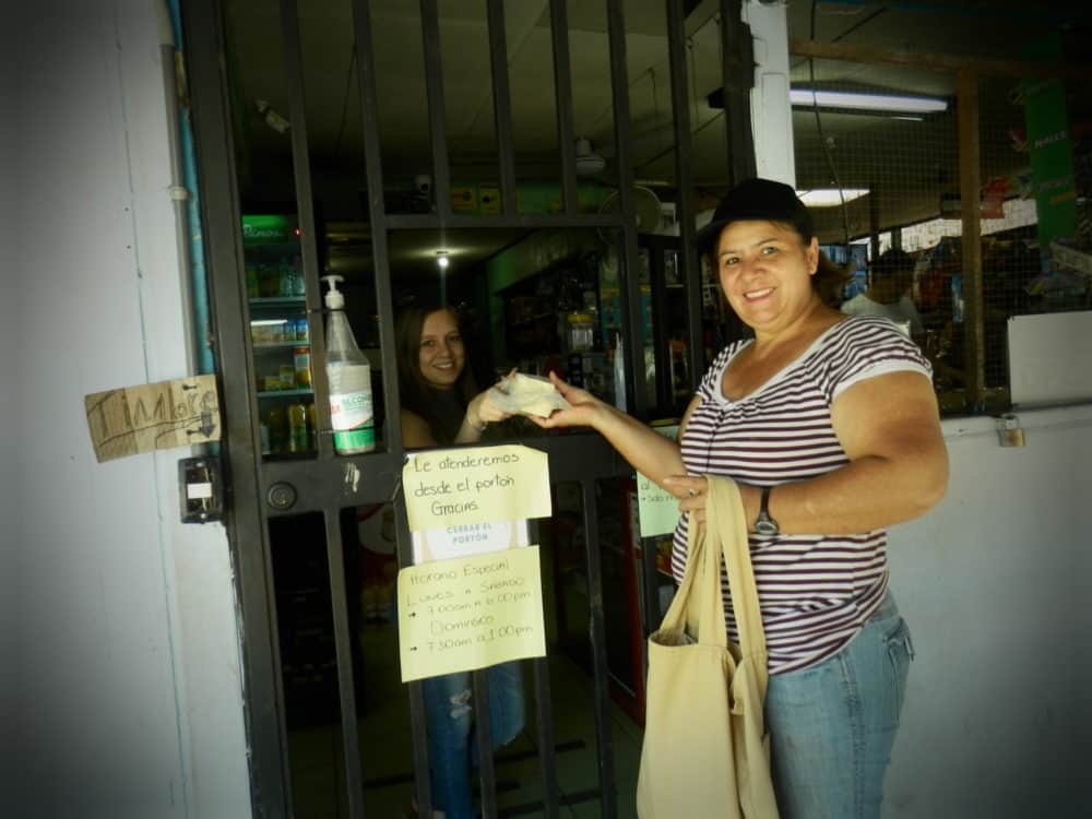 Keylin hands a bag to a customer.