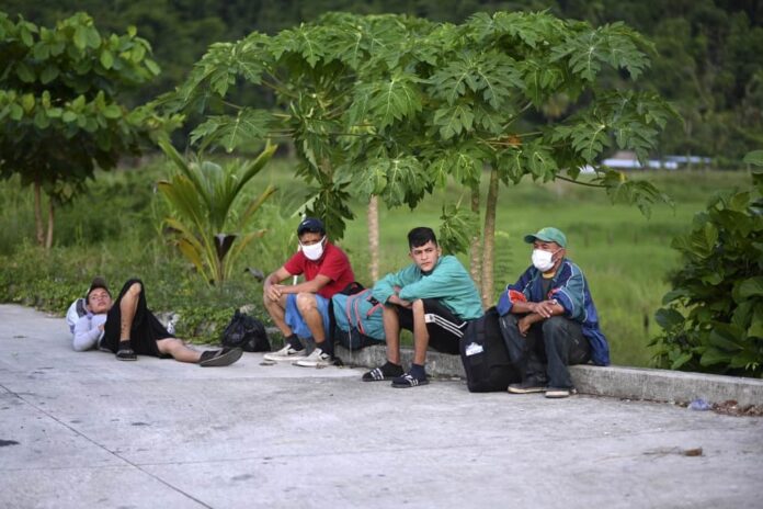 Inmigrantes hondureños, parte de una caravana con destino a Estados Unidos, descansan luego de ser interceptados por miembros del Ejército de Guatemala en San Luis, departamento de Petén, Guatemala el 3 de octubre de 2020.