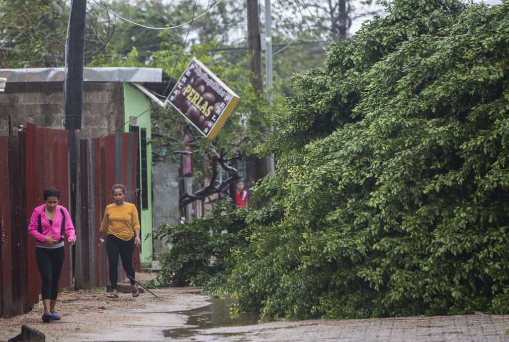 Women walk next to fallen trees as Hurricane Eta makes landfall in Bilwi, Puerto Cabezas, Nicaragua, on November 3, 2020.