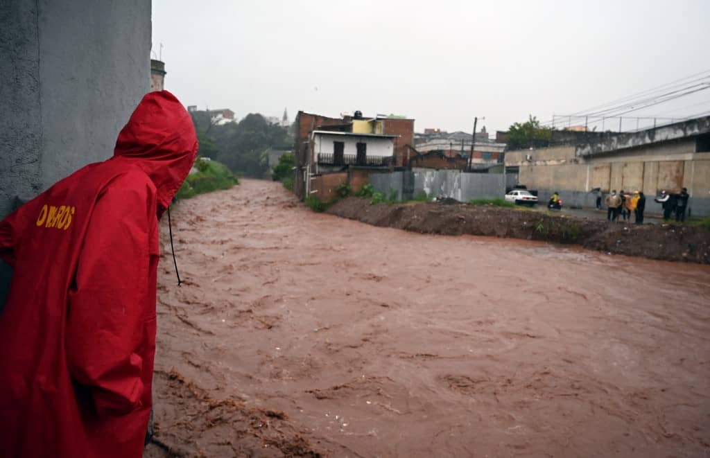 Locals look at the rising level of the Chiquito river, in La Hoya neighbourhood, in Tegucigalpa, following the passage of Hurricane Iota, on November 17, 2020.
