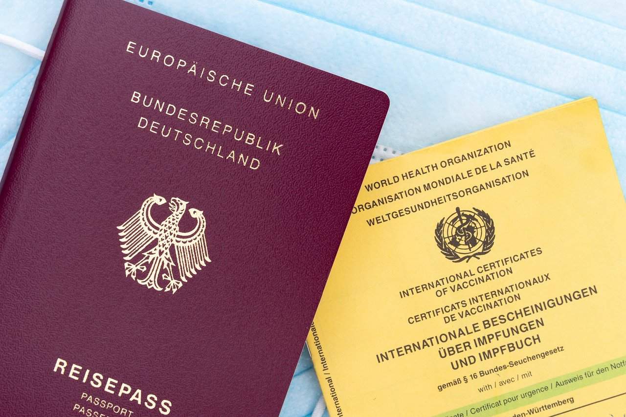 An EU passport alongside a WHO international vaccination certification card.