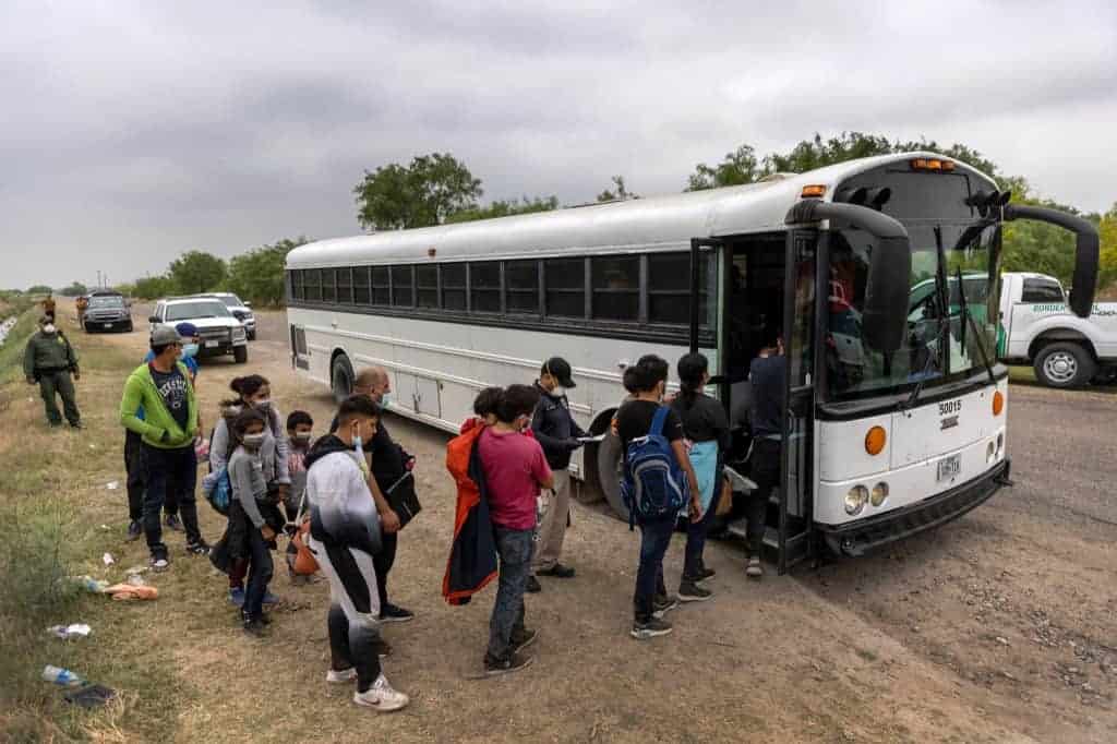 Central American families board a U.S. Customs and Border Protection bus for transport to an immigrant processing center after crossing the border from Mexico