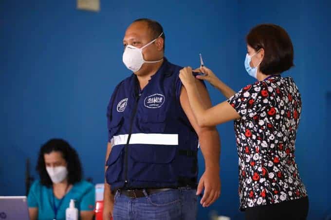 Alexander Solís of the National Emergency Commission receives the AstraZeneca coronavirus vaccine.