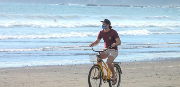 A tourist bikes on a Costa Rican beach.