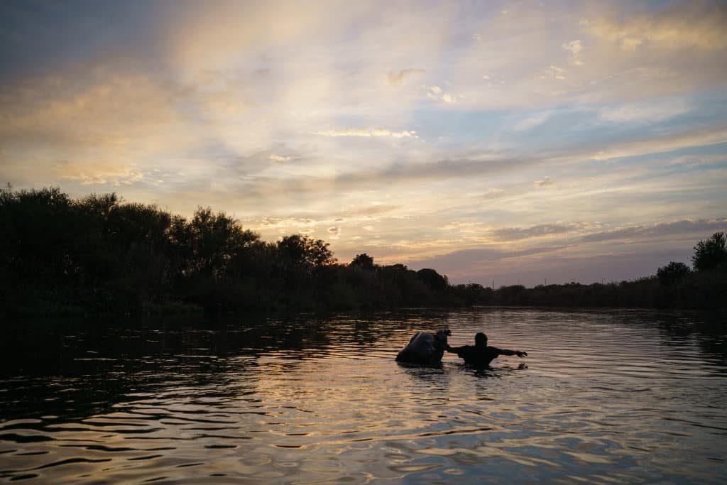 A Haitian man crosses the Rio Grande to the encampment on the Del Rio, Texas, side of the border from Ciudad Acuna, Coahuila state, Mexico on September 21, 2021.
