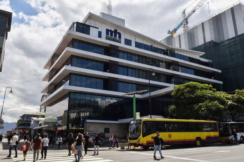 Pedestrians walk past the Costa Rican Ministry of Finance building in San Jose, Costa Rica