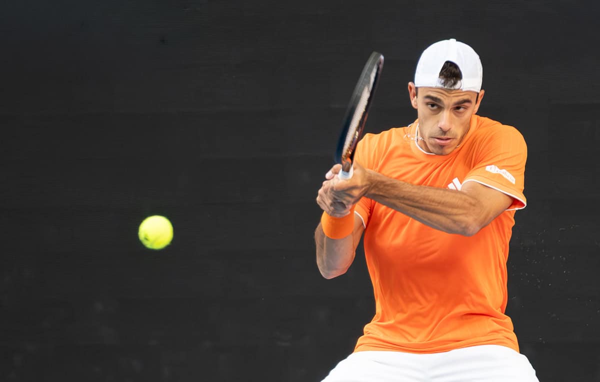 Argentine tennis player Francisco Cerúndolo hits a two-handed backhand at the 2026 Australian Open