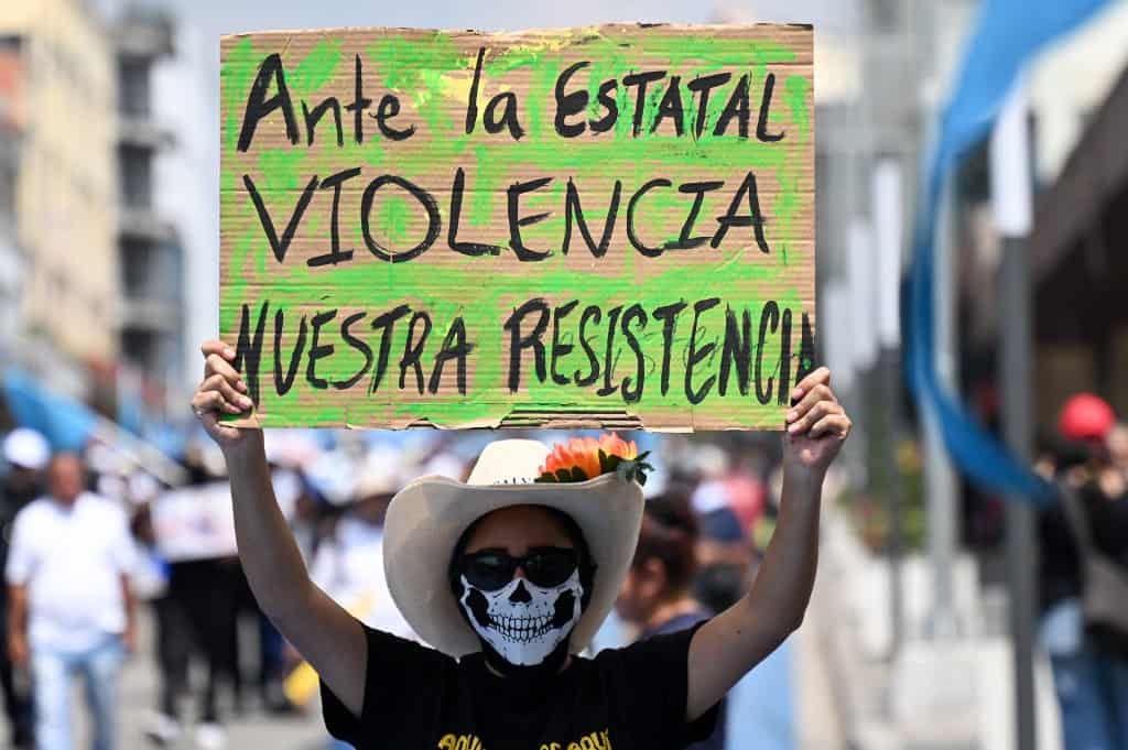 A protestor with a sign at at El Salvador Protest