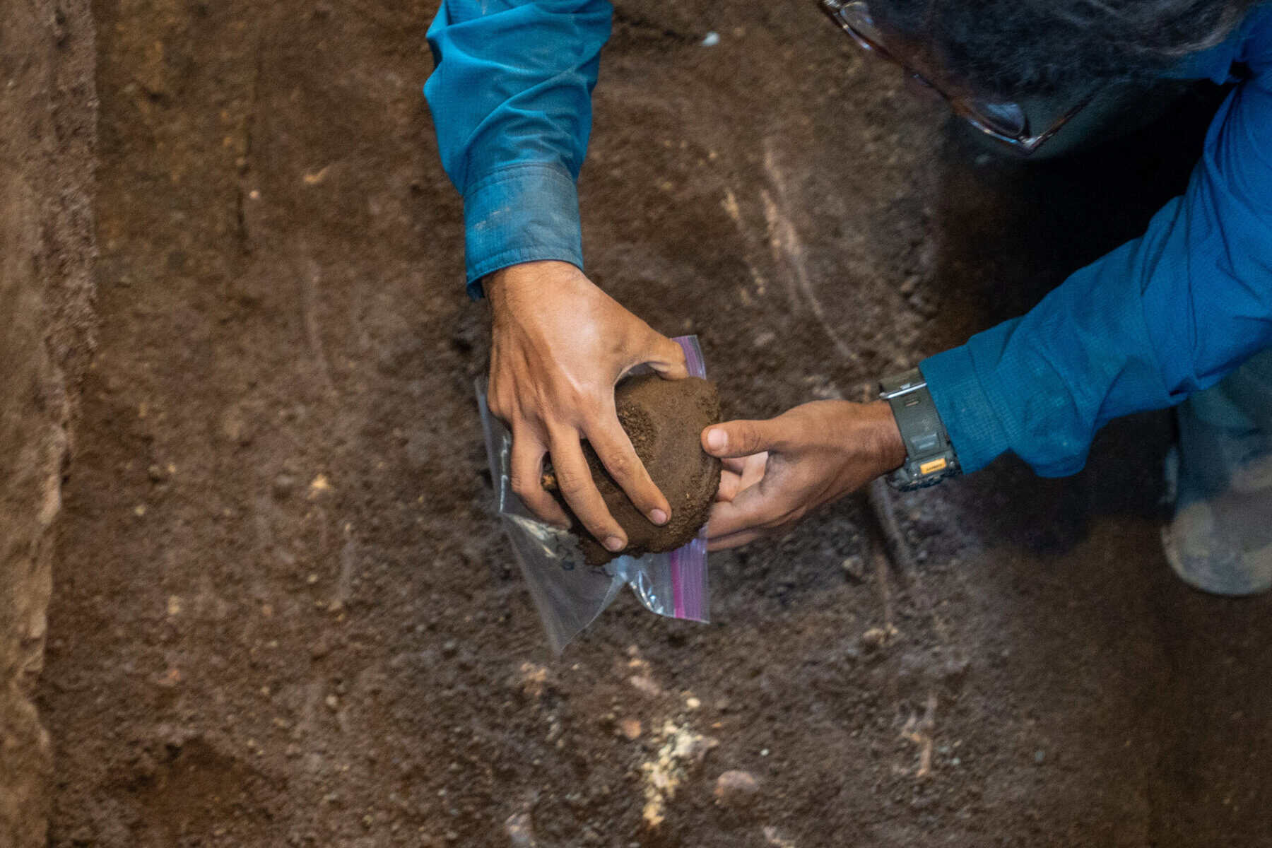 archaeologist handling a ceramic vessel recovered from a pre-Hispanic burial