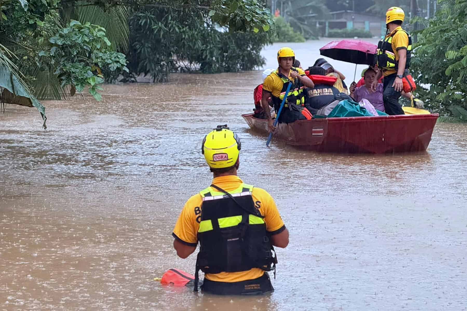 Costa Rican firefighters ferry stranded residents by boat through floodwater in Limón province
